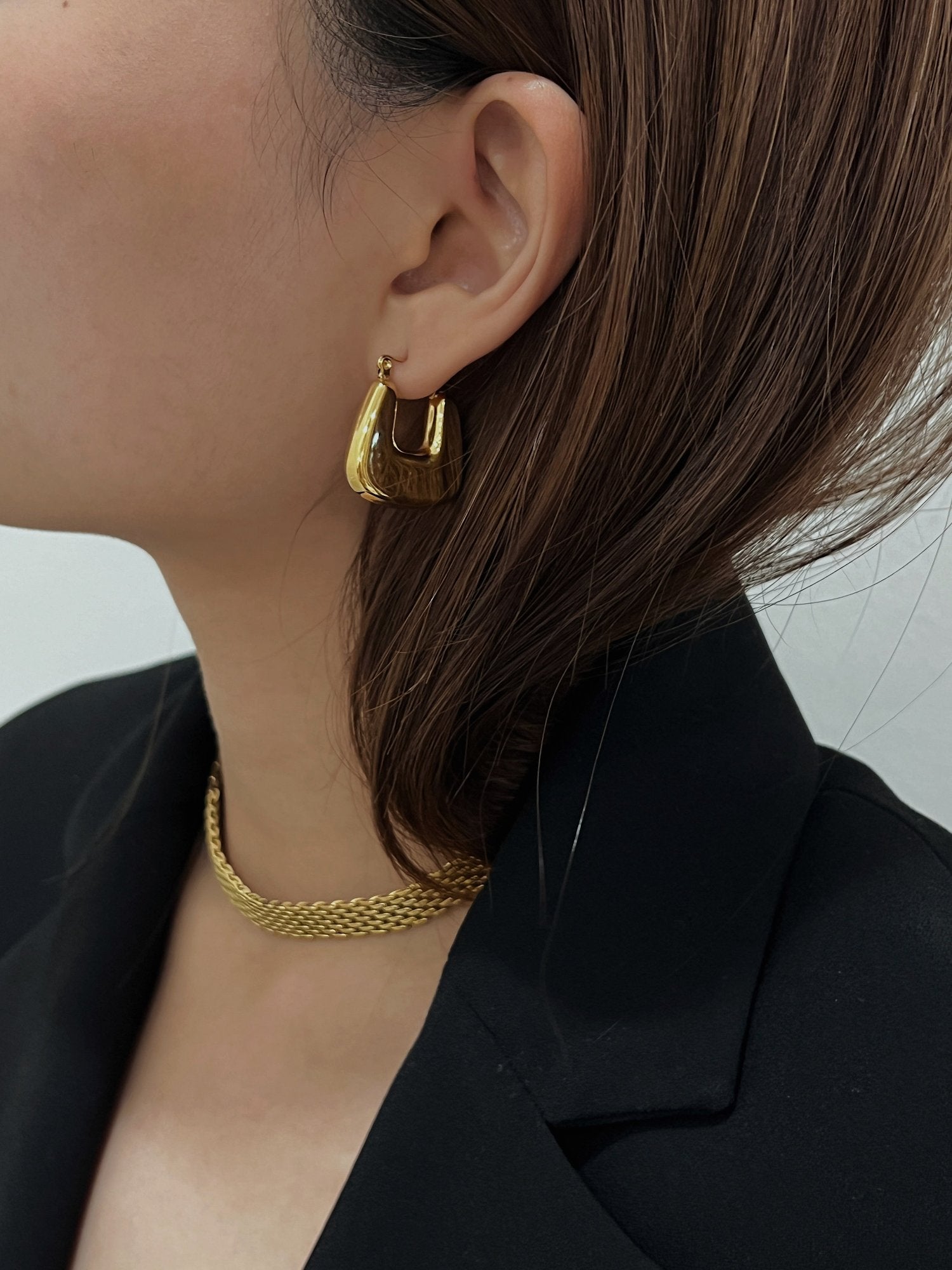 Aurous atelier modern luxe presentation showcasing a woman personalizing her minimal tailored jewelry capsule