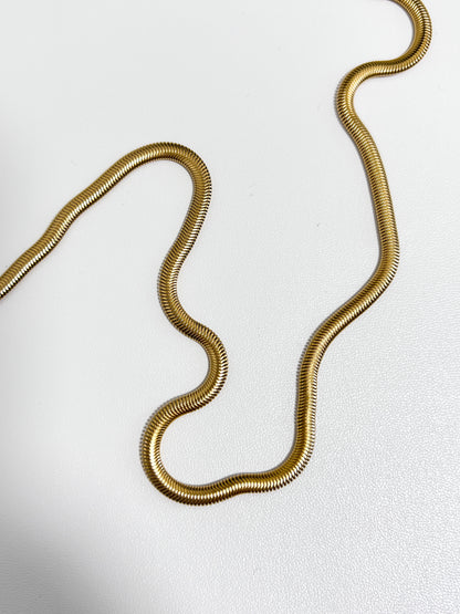 Bespoke studio product asset showing a thick gold liquid herringbone ribbon resting on a white background