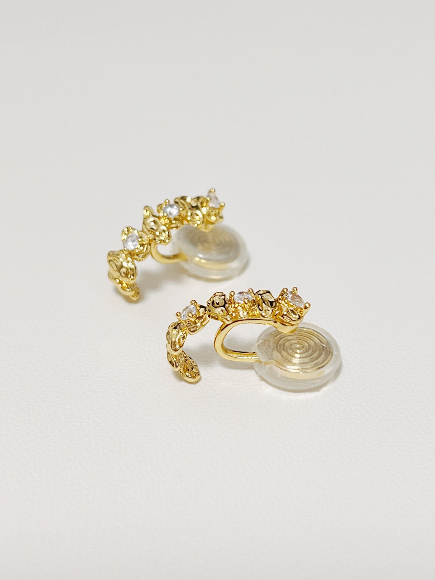 A close-up technical shot showcasing the integrated low-profile comfort tension clip backing of a gold climber earring