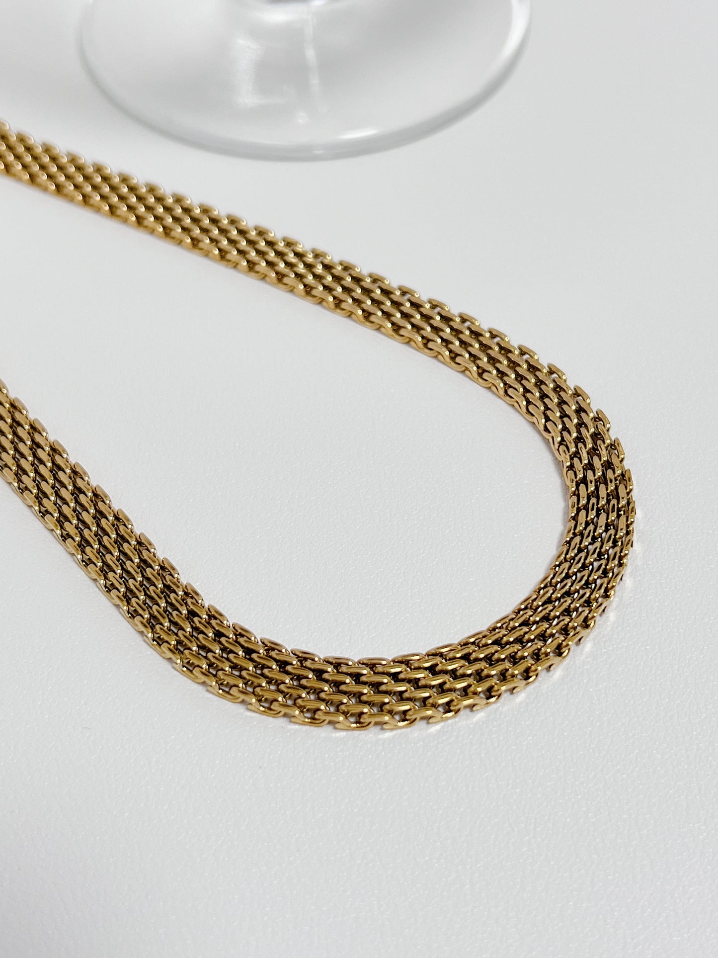 Close up view of the intricate micro woven link pattern on a premium golden mesh statement collar