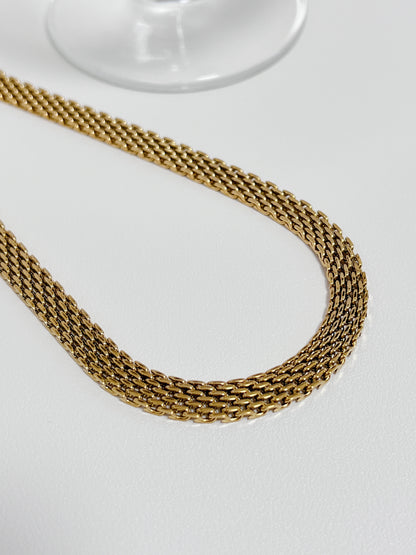 Close up view of the intricate micro woven link pattern on a premium golden mesh statement collar