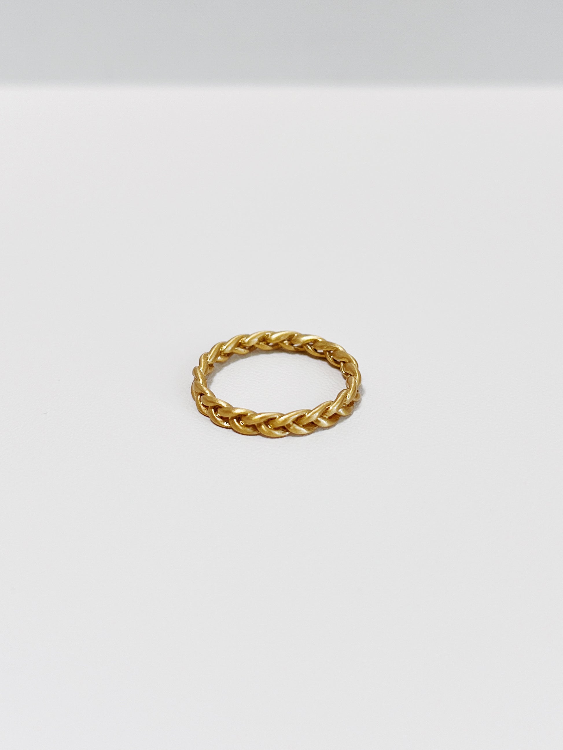 Close-up of Irene Gold braided ring in 3mm on a white background