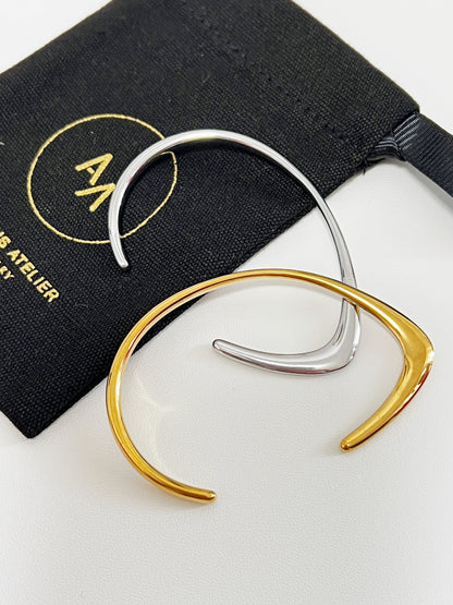 Still life arrangement showing the silver and gold irregular bangles intersecting to show how they layer together.