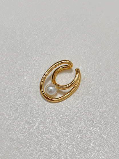 Flat lay close-up of the Karolina Pearl Earlobe Cuff in premium gold plating, highlighting its continuous organic fluid lines and the luminous reflection of its high-luster pearl.