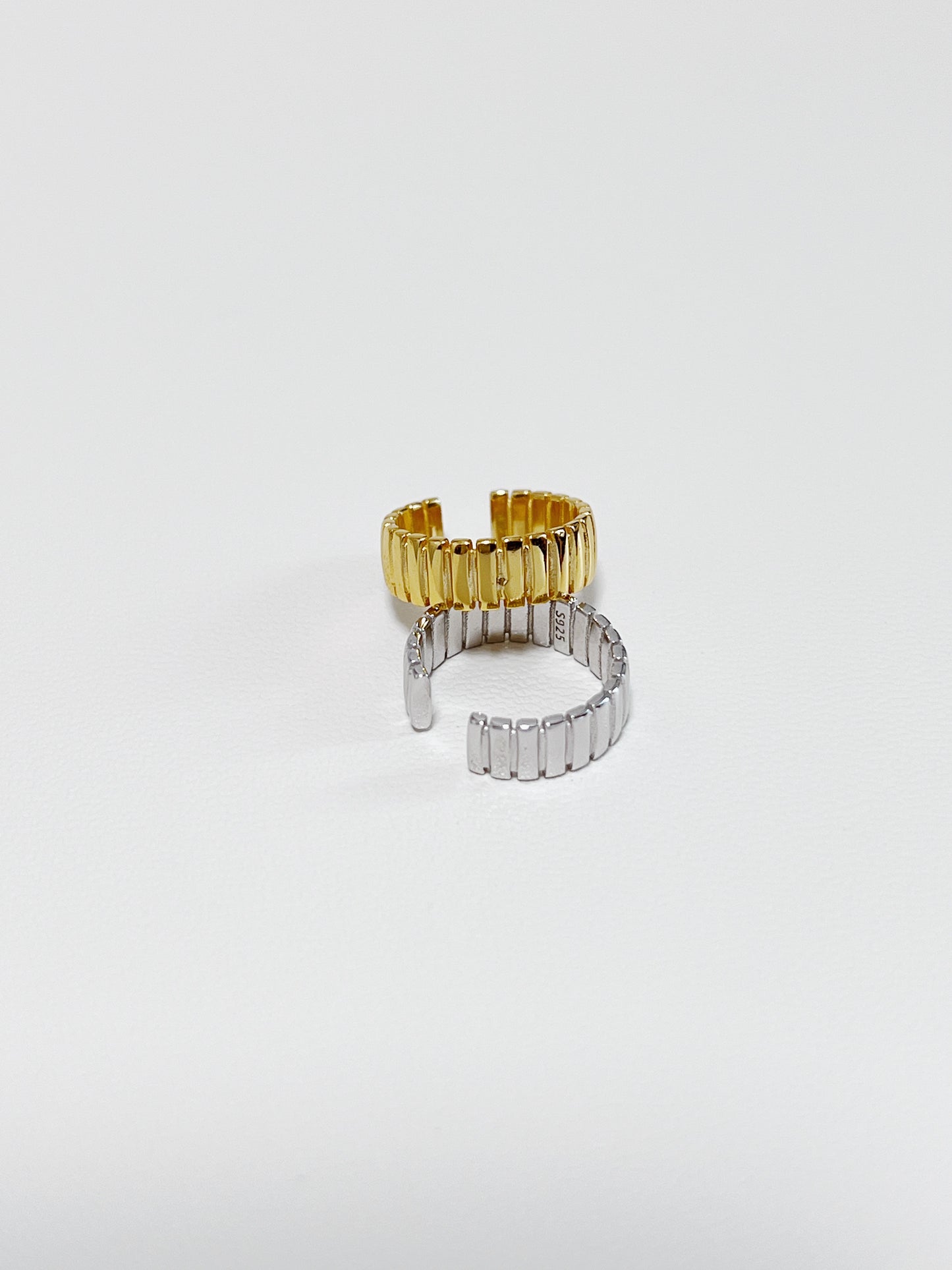Macro shot of ribbed texture on Kate gold cuff and silver cuff.
