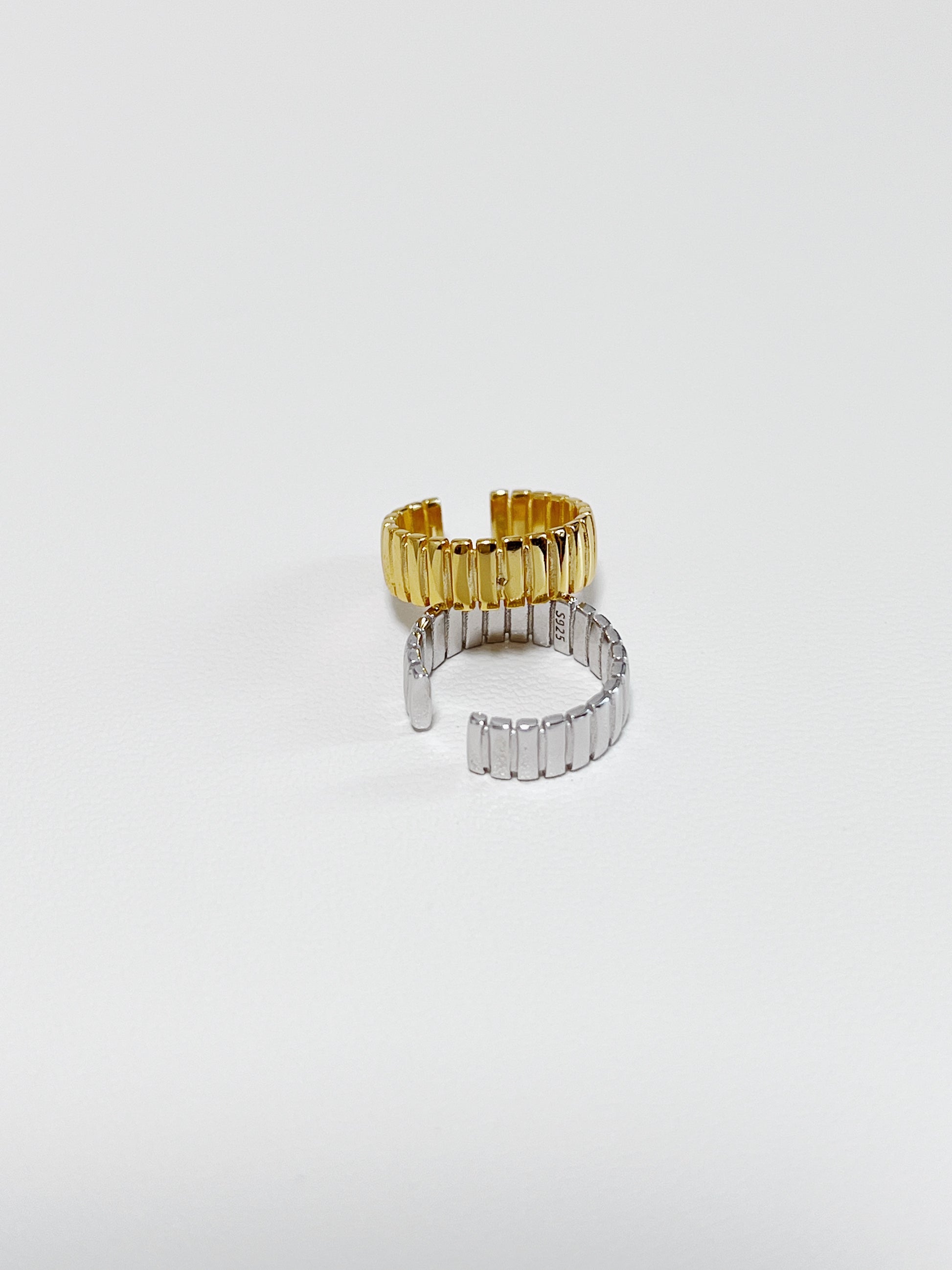 Macro shot of ribbed texture on Kate gold cuff and silver cuff.