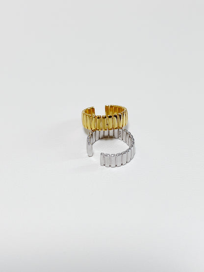 Macro shot of ribbed texture on Kate gold cuff and silver cuff.