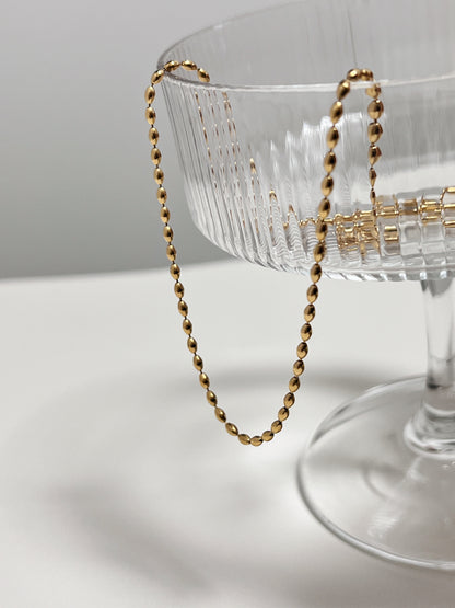 Premium demi fine jewelry showcase highlighting the uniform calibration of an elliptical bead chain