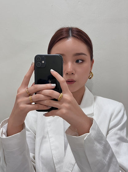 Lifestyle selfie shot of thick gold ridged ring and ribbed rings with white outfit