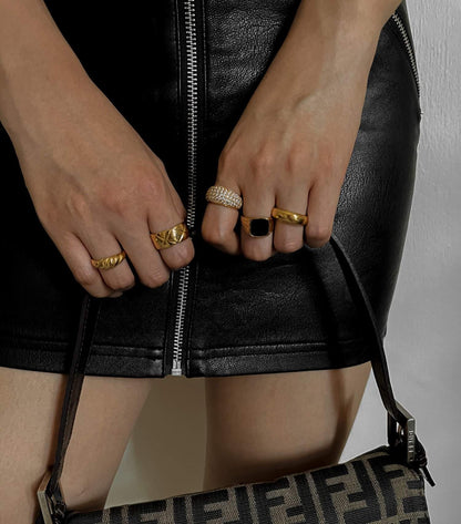 Stack of gold eternity band and gold statement rings on model fingers