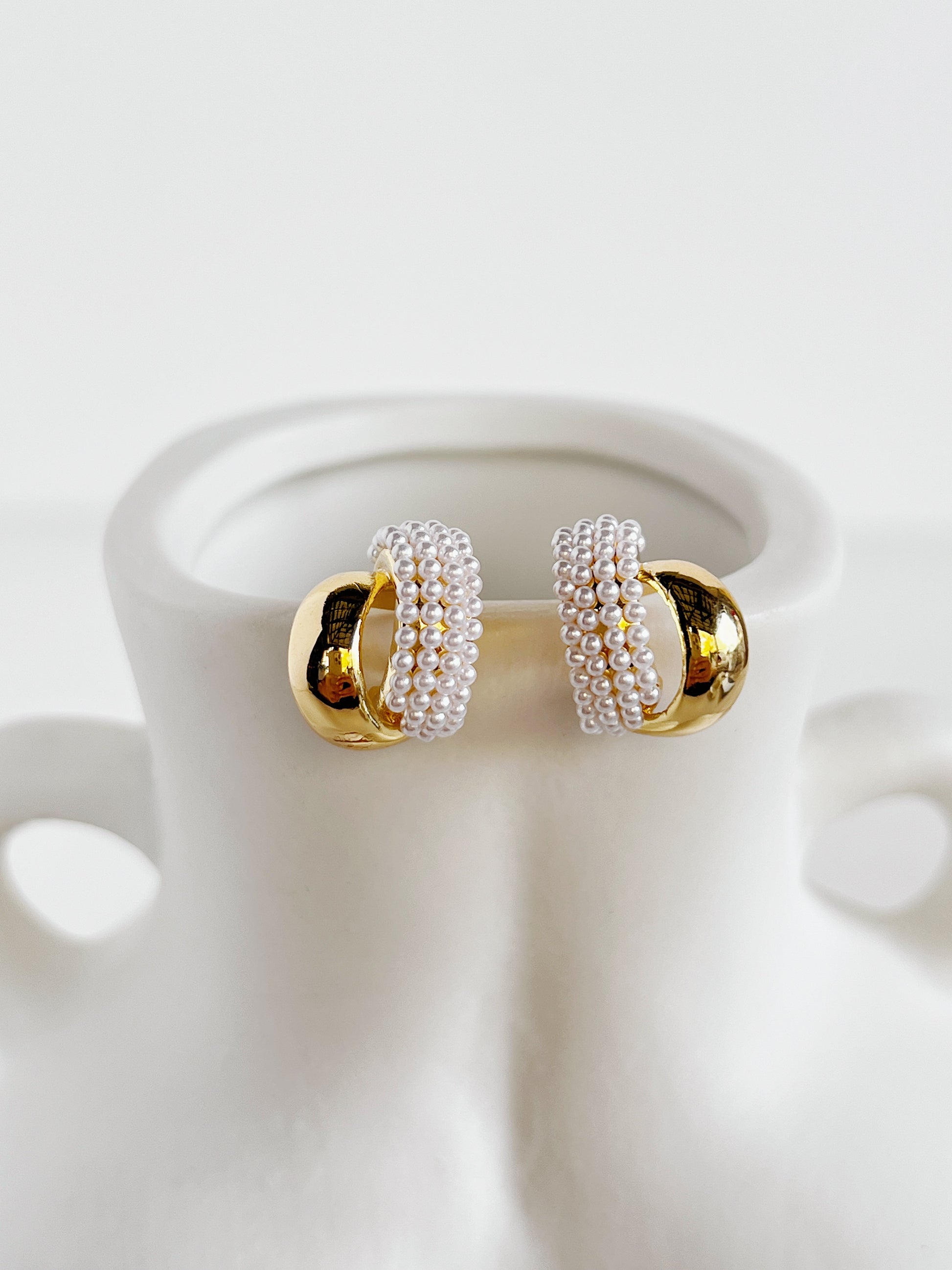 Contemporary luxury statement studs showcasing parallel gold and organic pearl tracks