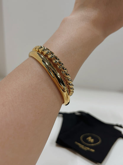 Model showcasing the weightless drape and effortless stacking potential of our signature gold statement wrist cuffs.