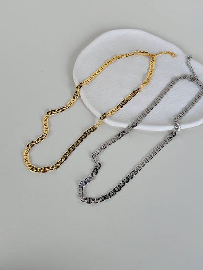 Detailed image focusing on the streamlined luxury lobster clasp and adjustment links of a brass-core chain