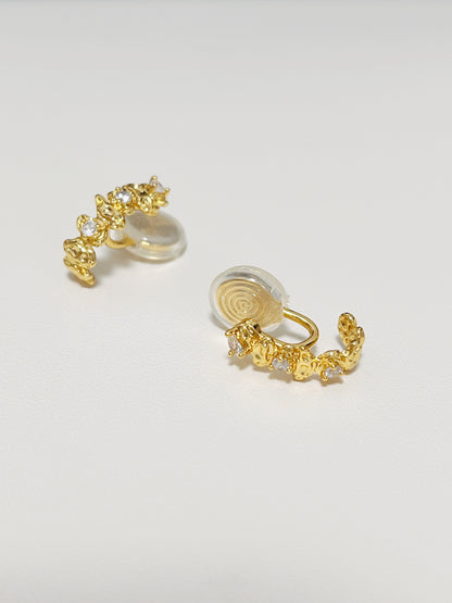 Macro jewelry photography highlighting the hand-set 5A cubic zirconia stones clustered along an 18k gold PVD frame