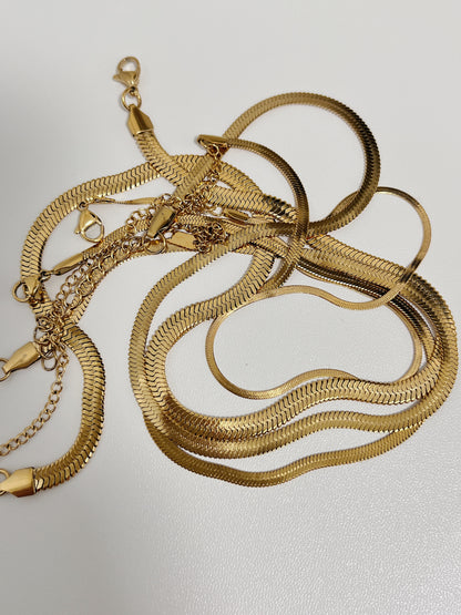Macro shot of the high shine gold herringbone ribbon links detailing the premium lobster clasp enclosure
