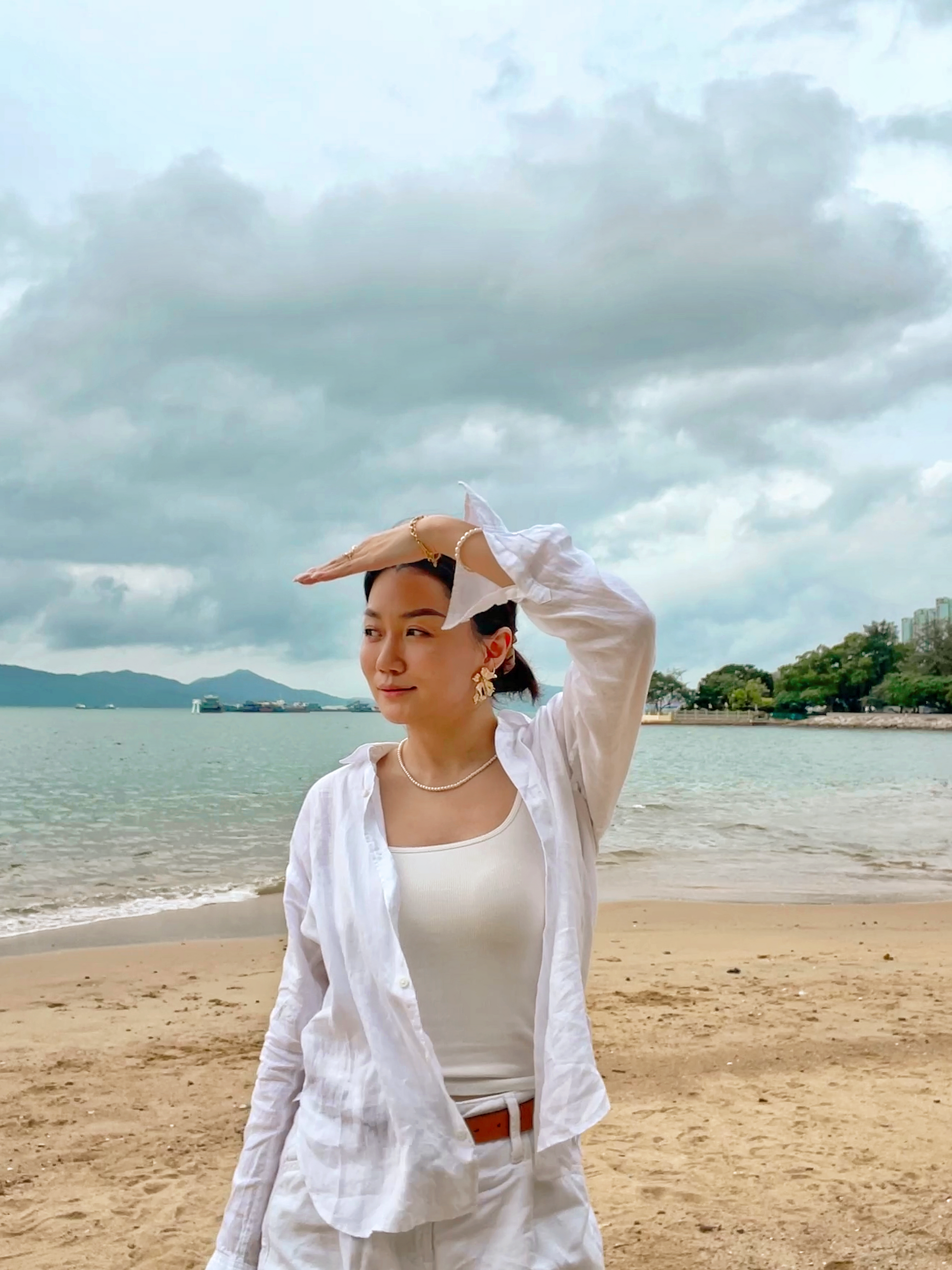 Editorial beach fashion aesthetic displaying a modern single strand tiny pearl jewelry layout paired with crisp linen apparel