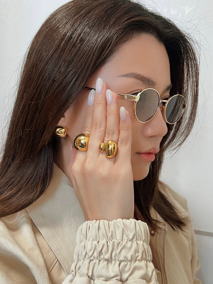 Side view of a model accessorized with the Marseille shades, highlighting the elegant slope of the thin gold arms against natural ambient lighting.