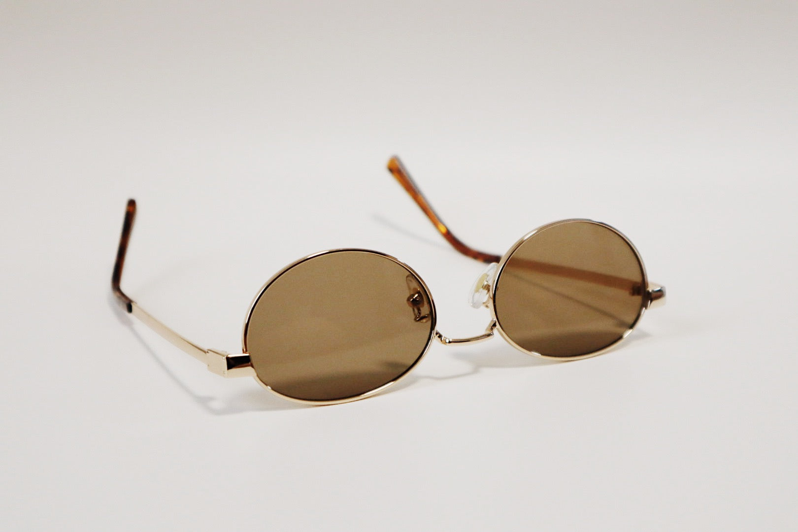 Studio detail shot of the Marseille frames focusing on the solid, uniformly saturated amber lens clarity and the slim gold metallic rim.