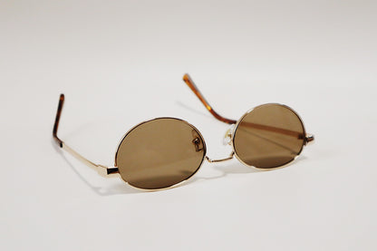 Studio detail shot of the Marseille frames focusing on the solid, uniformly saturated amber lens clarity and the slim gold metallic rim.
