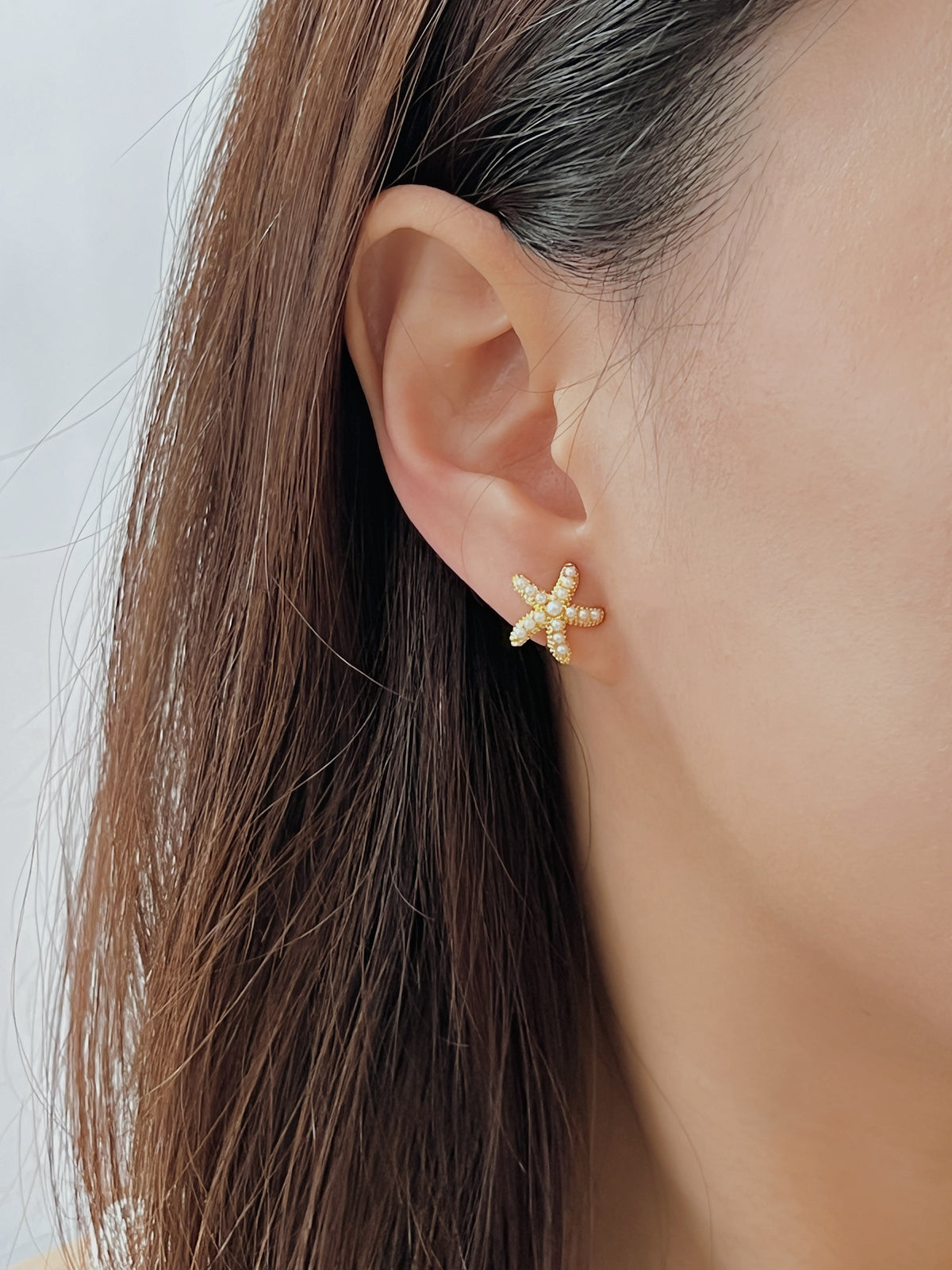 Side profile showing how the 13mm starfish stud sits completely flush against the earlobe.
