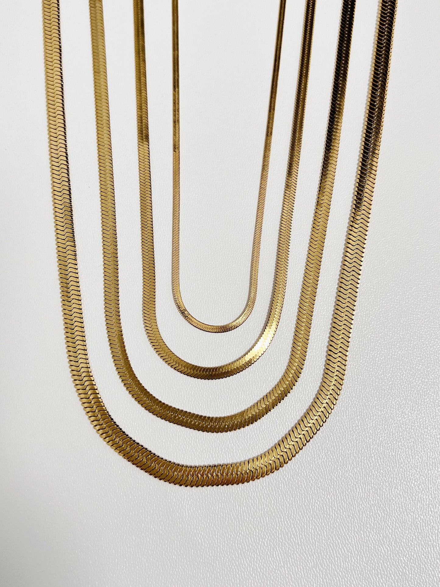 Close up perspective of tarnish resistant 18k gold pvd snake chain jewelry showing the reflective smooth surface