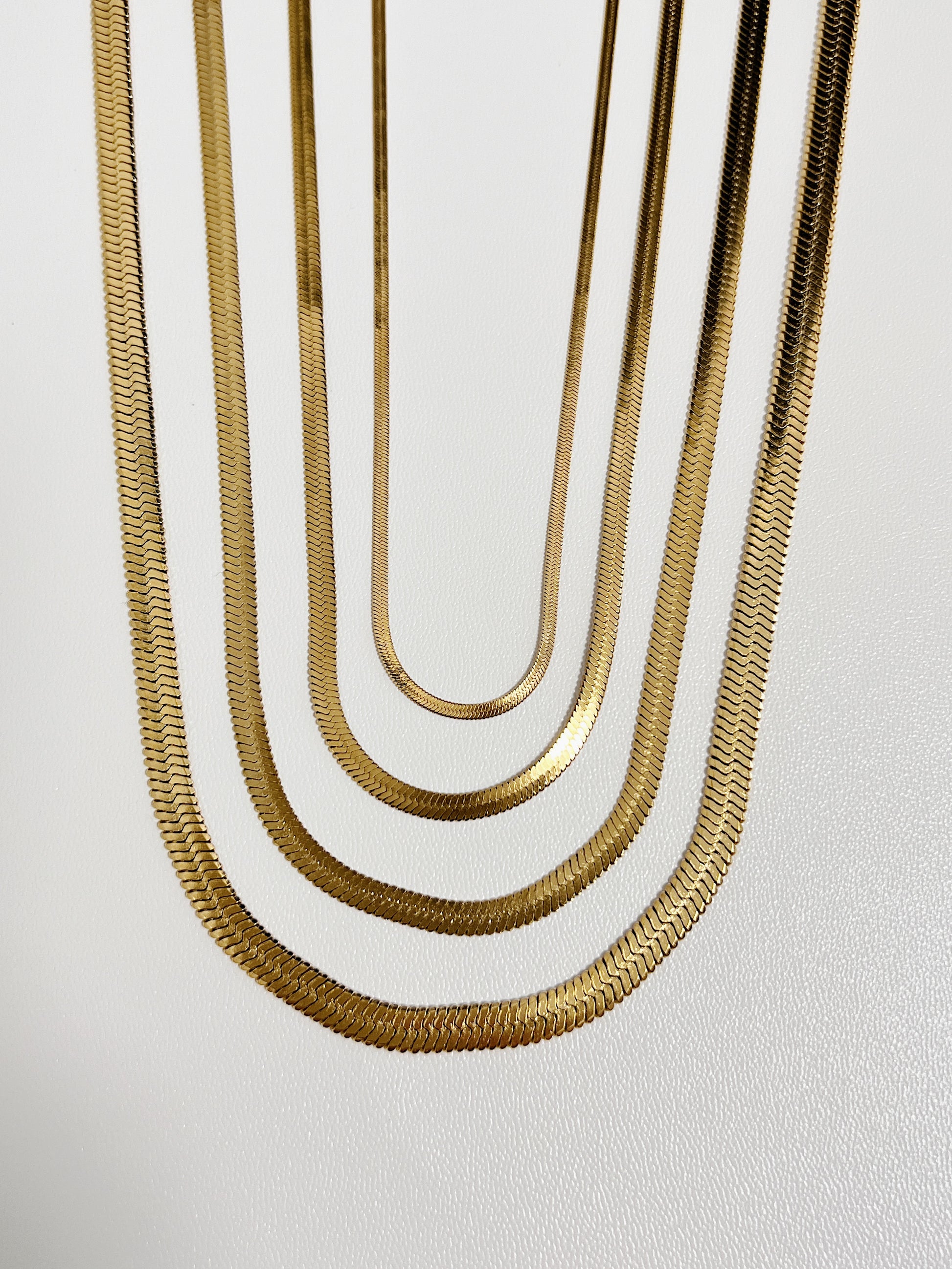 Close up perspective of tarnish resistant 18k gold pvd snake chain jewelry showing the reflective smooth surface