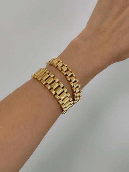 Model showing both 10mm and 15mm gold watch link bracelets stacked together on arm.