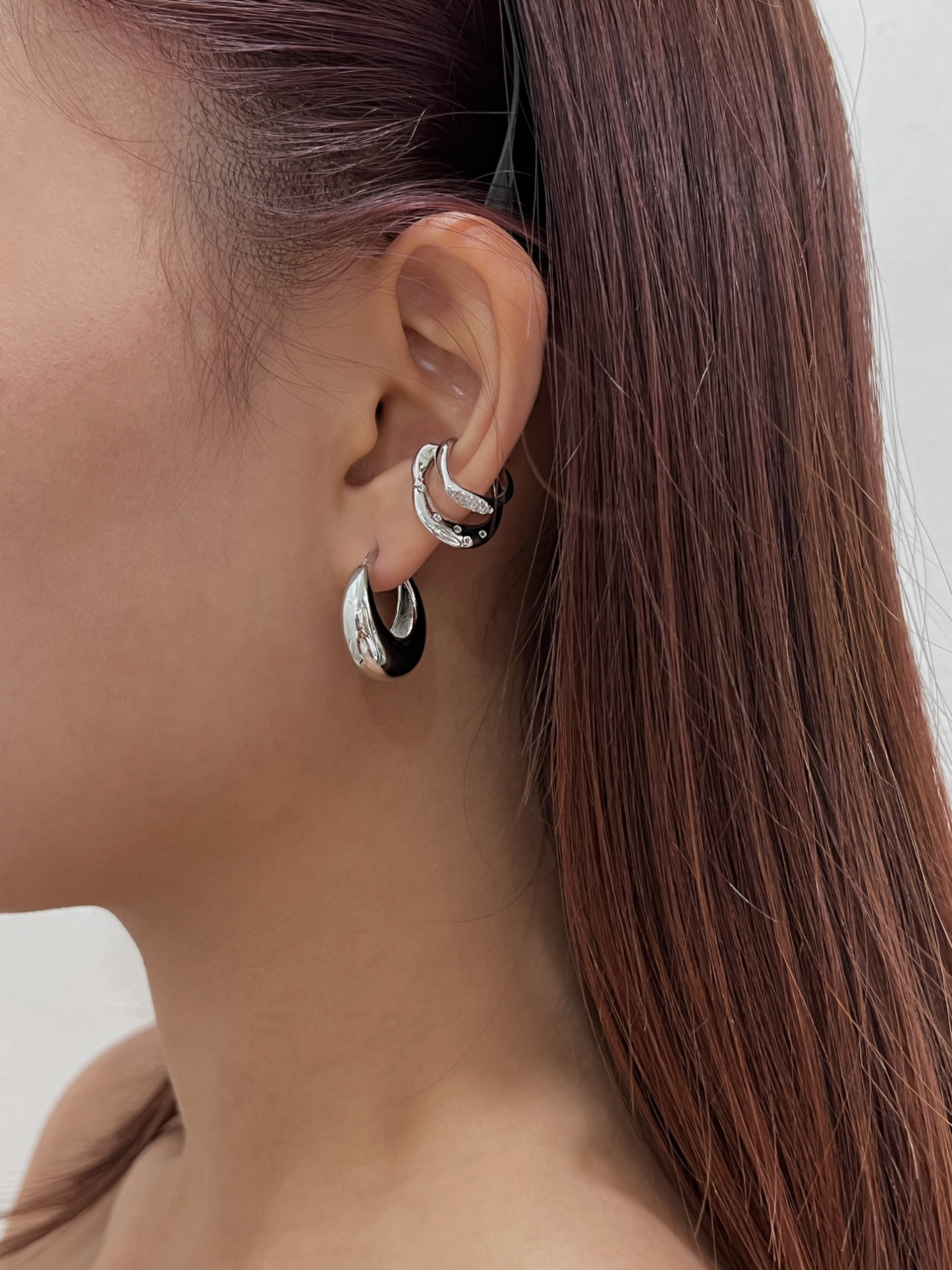 Multi-layered ear stack featuring Ashley Silver Cuff and silver hoops.