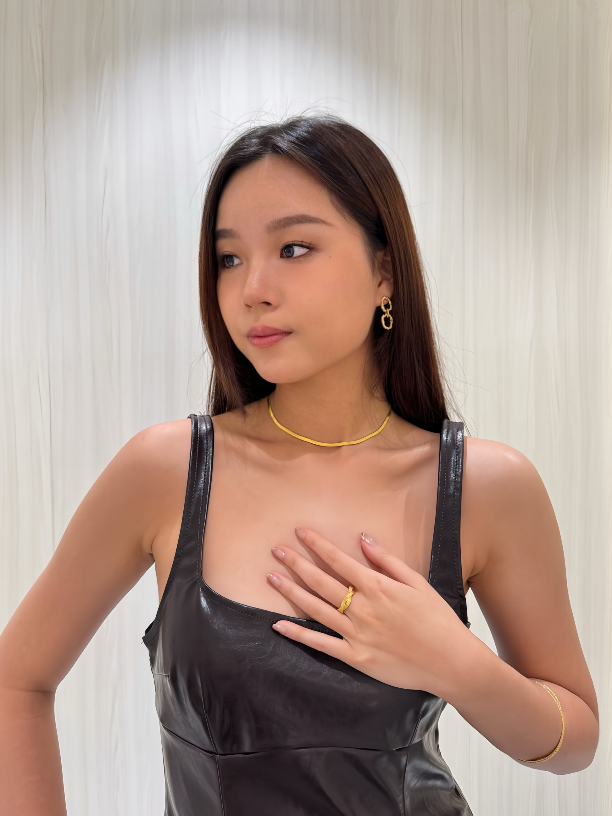 Model wearing the Aurorette braided matte gold ring with a brown leather dress