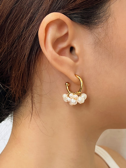 Side profile shot of a model wearing the Freya Cluster Freshwater Pearl Earring Hoops, showcasing the face-framing shimmer of the organic pearl cluster.