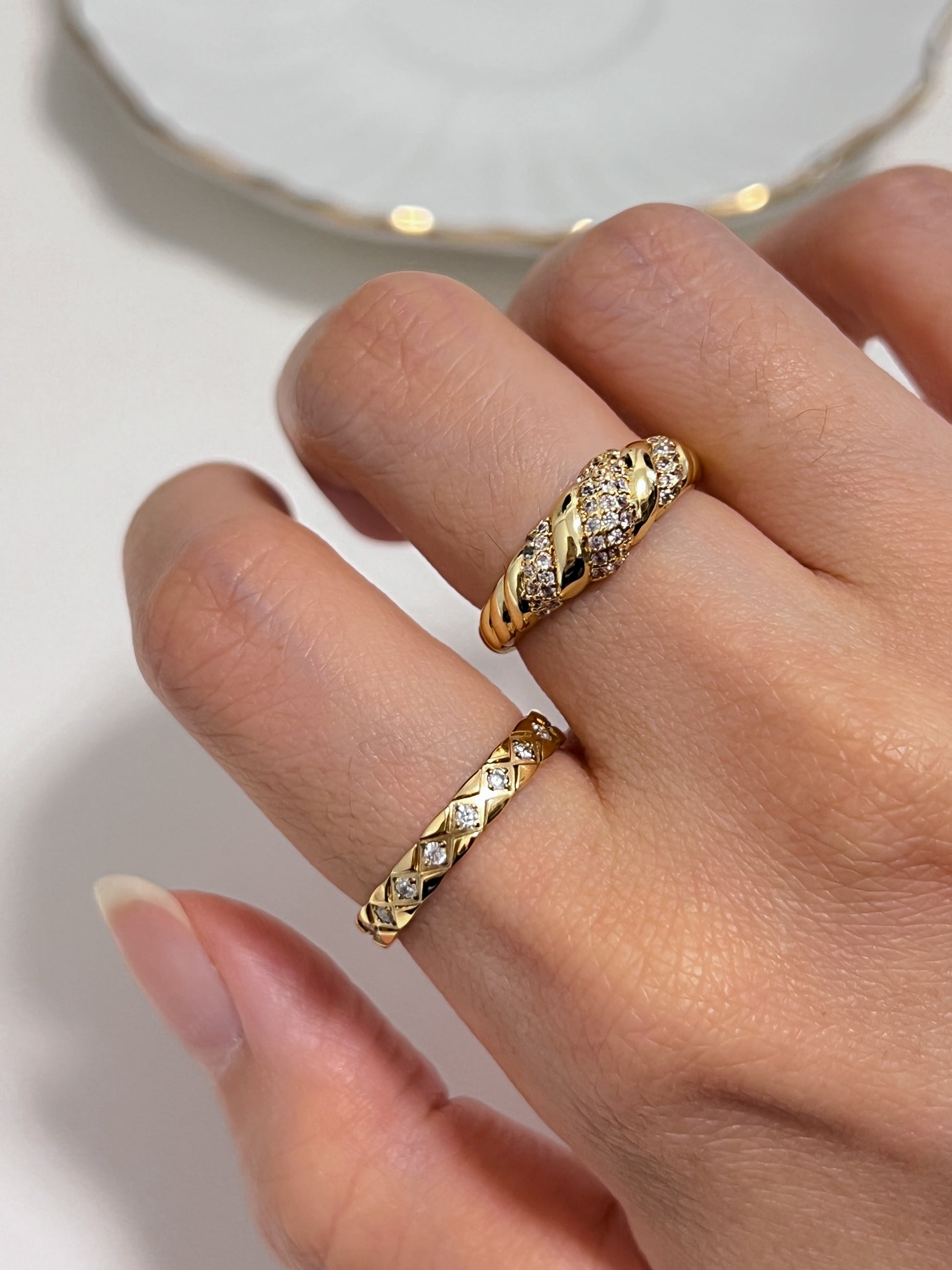 Model layering the Claudia gold ring with a minimalist gold band stack.
