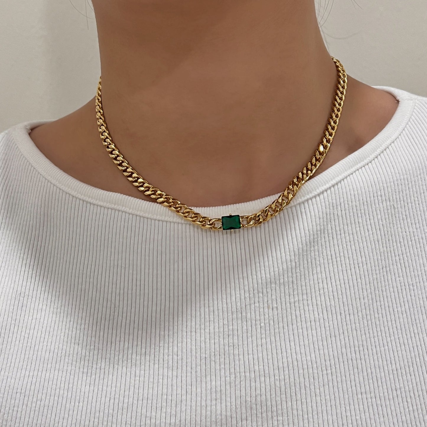 Model collarbone view styling elegant green rectangle pendant necklace over white ribbed top