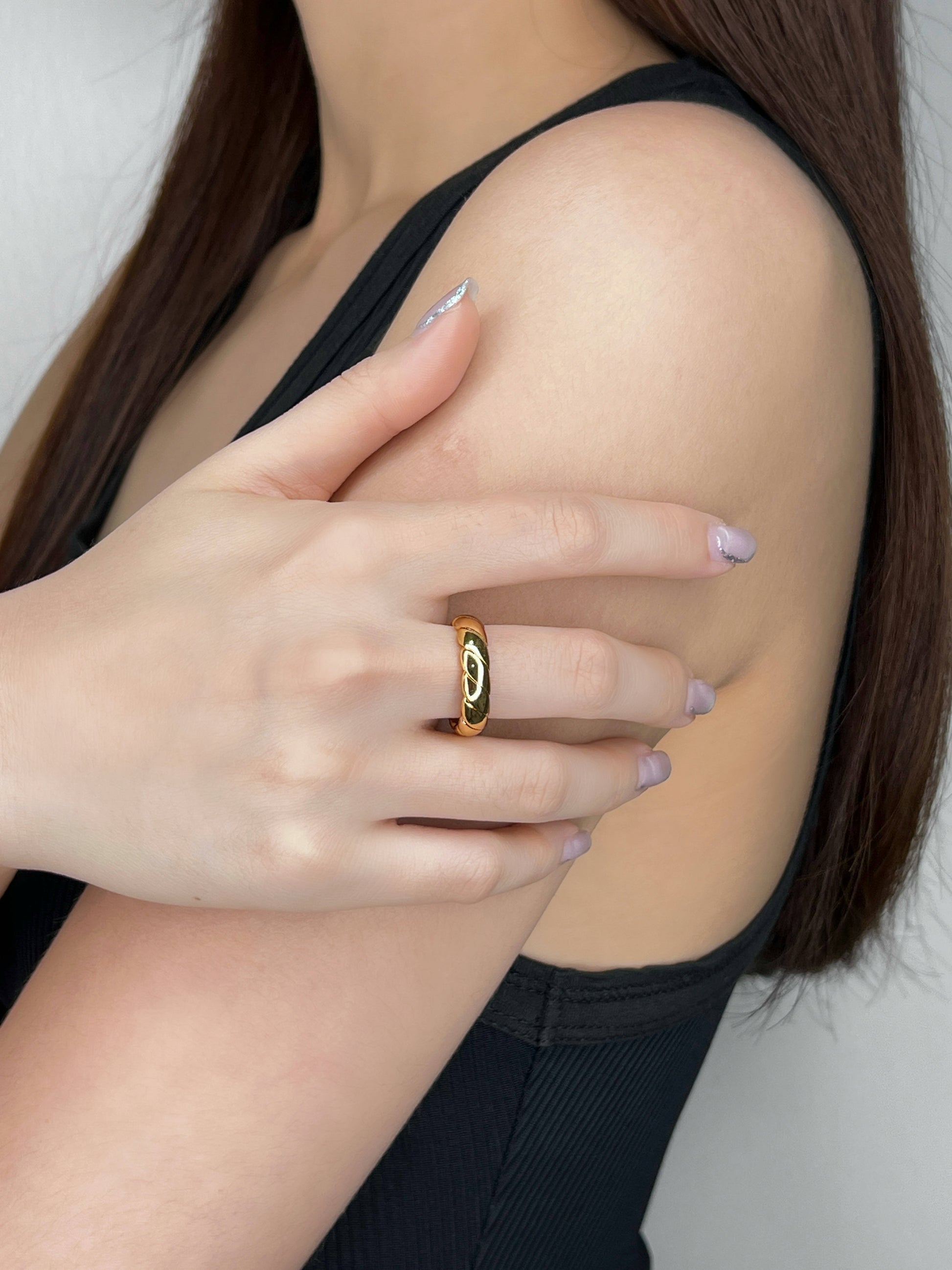 Model hand wearing polished rope twist stacking ring on middle finger