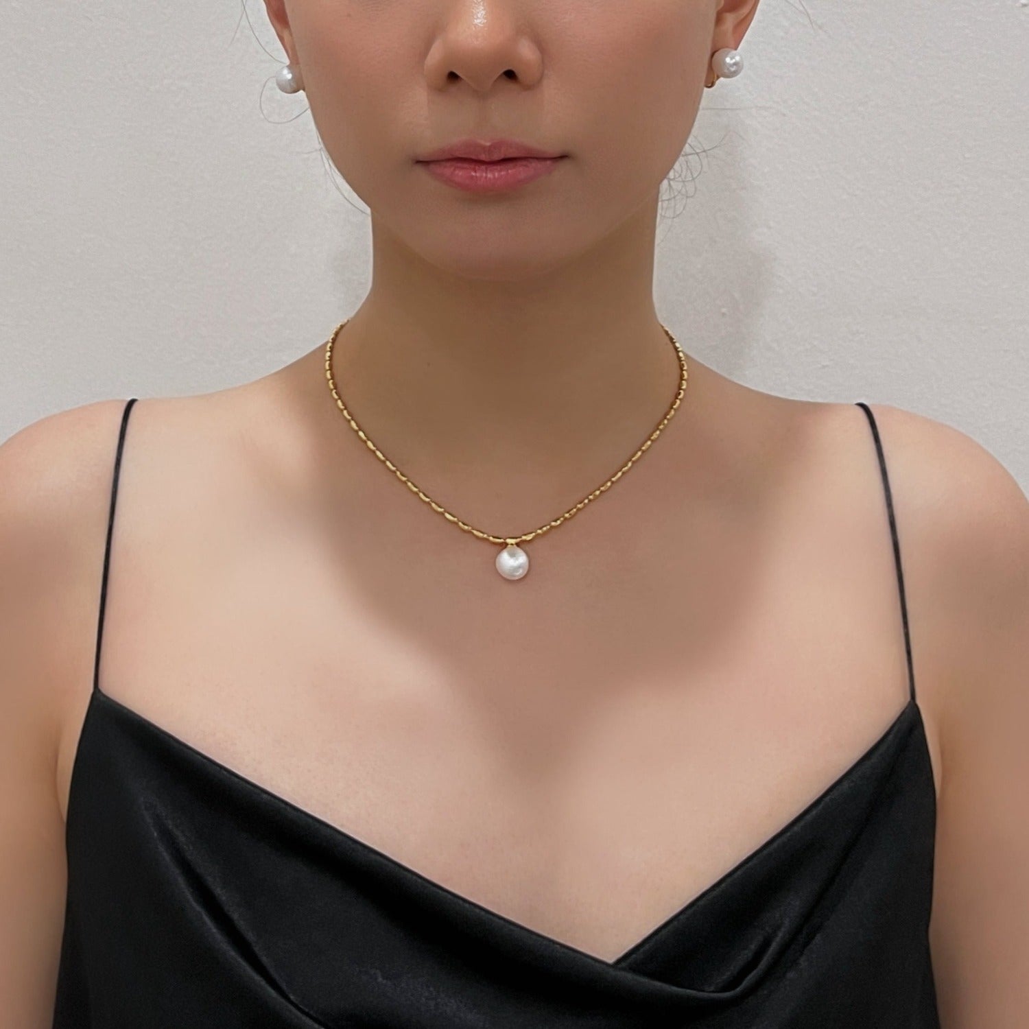 Model collarbone view styling the marjorie gold bead pearl necklace with a minimalist black silk dress