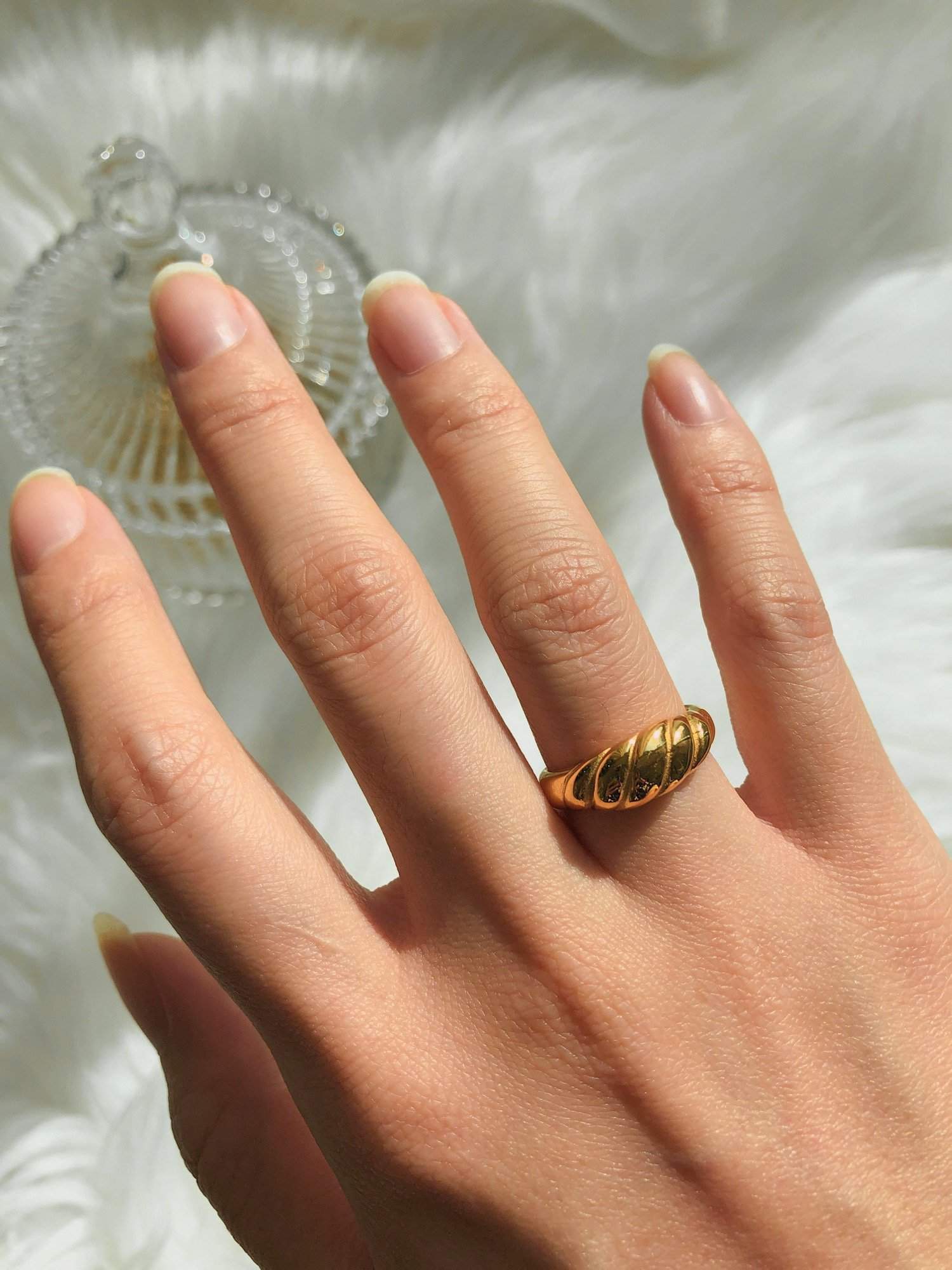 luxury styling of gold croissant ring on a hand model