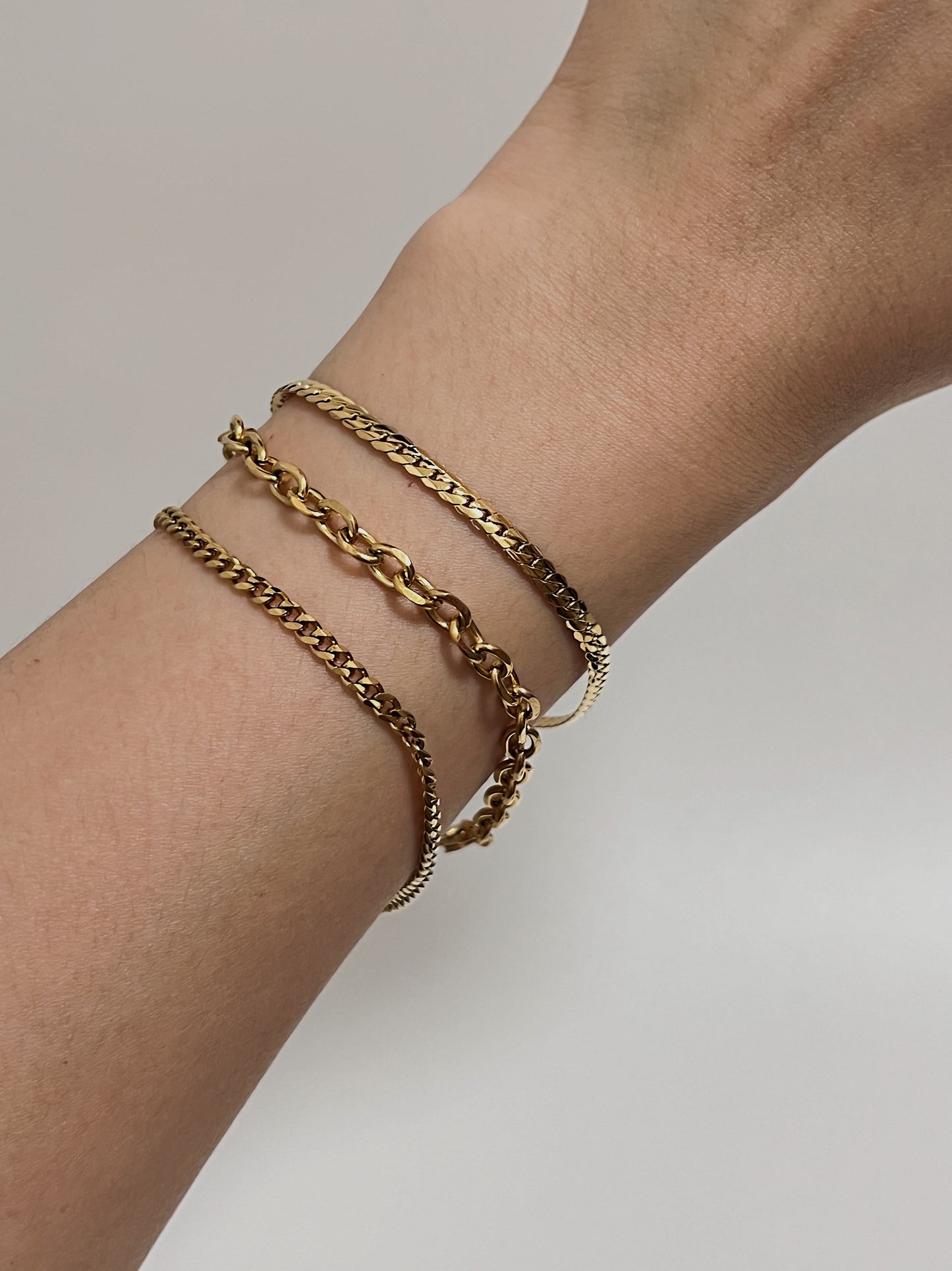 Casual on-model look showing the bright, warm gold luster of the cable chain and other chain necklace under natural studio lighting.