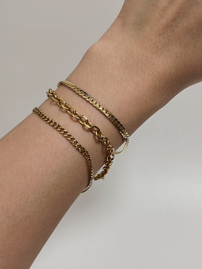 Casual on-model look showing the bright, warm gold luster of the cable chain and other chain necklace under natural studio lighting.