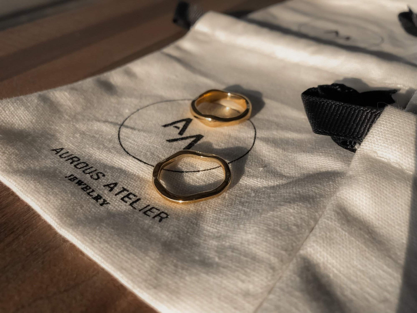 Ida thick wavy gold band highlighting its liquid metal architecture.