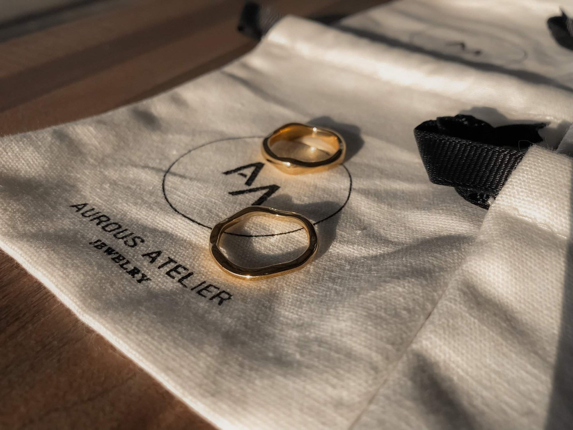 Ida thick wavy gold band highlighting its liquid metal architecture.