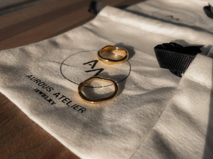 Ida thick wavy gold band highlighting its liquid metal architecture.