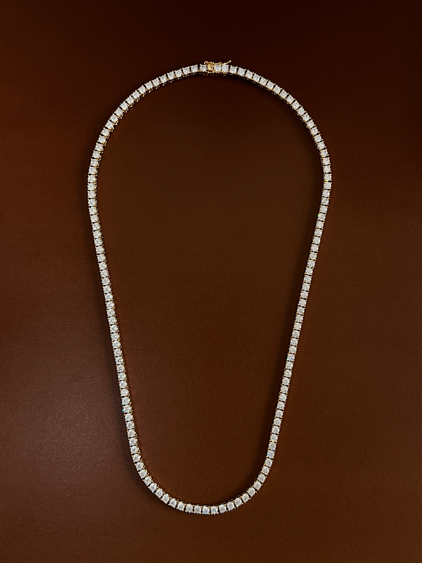 Monica classic tennis necklace continuous 5A cubic zirconia arrangement on brown surface