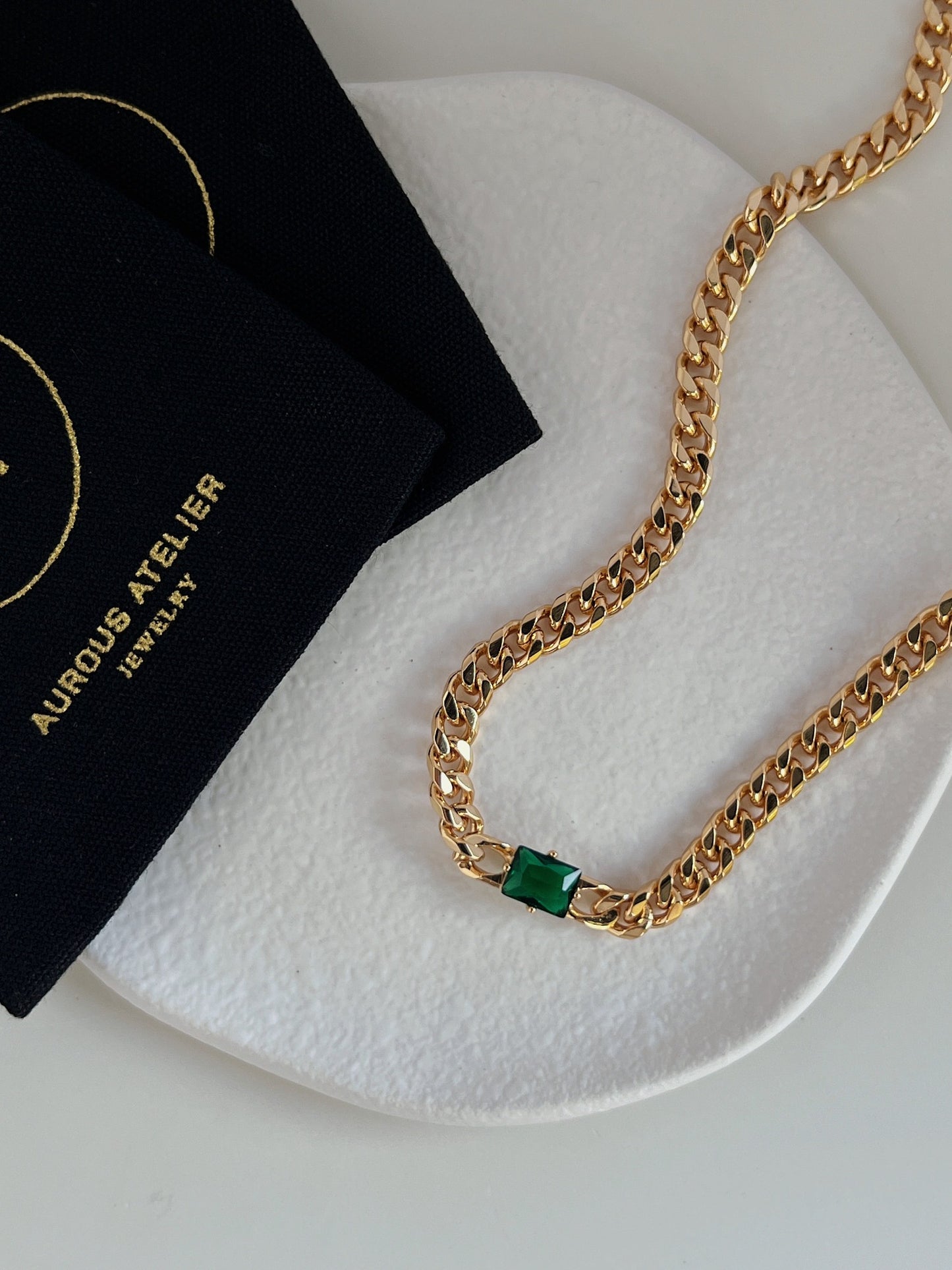 Nina emerald green rectangle pendant necklace in gold bezel setting on minimalist stone tray