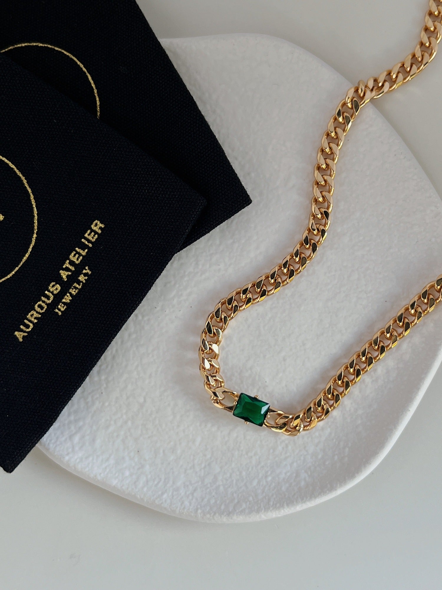Nina emerald green rectangle pendant necklace in gold bezel setting on minimalist stone tray