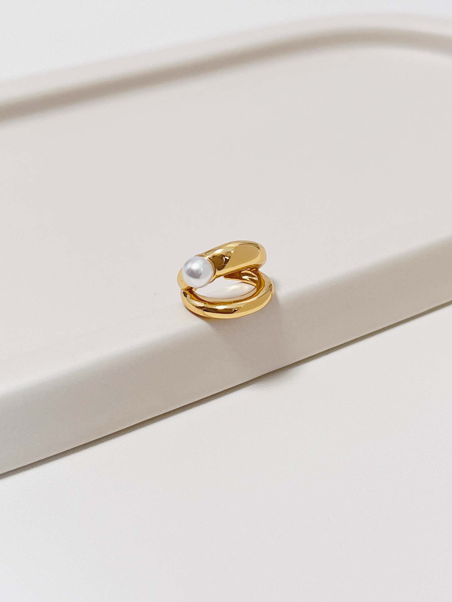 The Dior Pearl Cuff floating over a minimalist background to emphasize its clean, symmetrical profile.