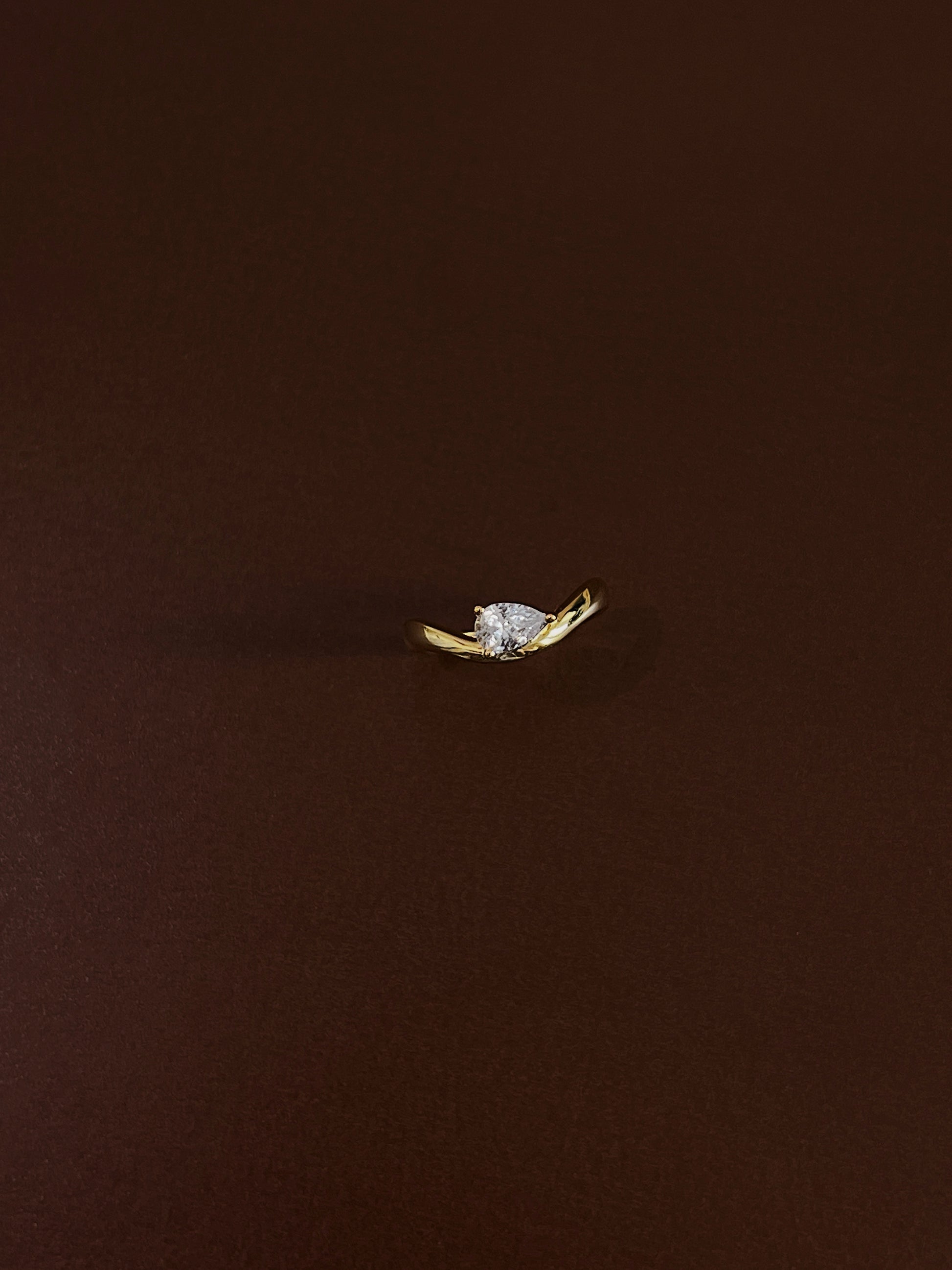 vvs1 moissanite pear cut gem detail on gold wave band
