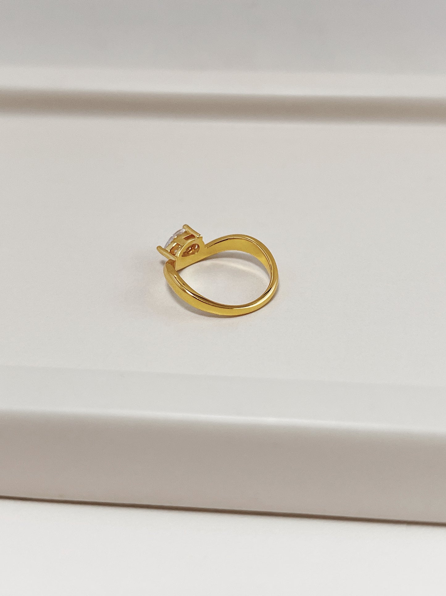 side profile view of pear cut moissanite setting and tapered wave band