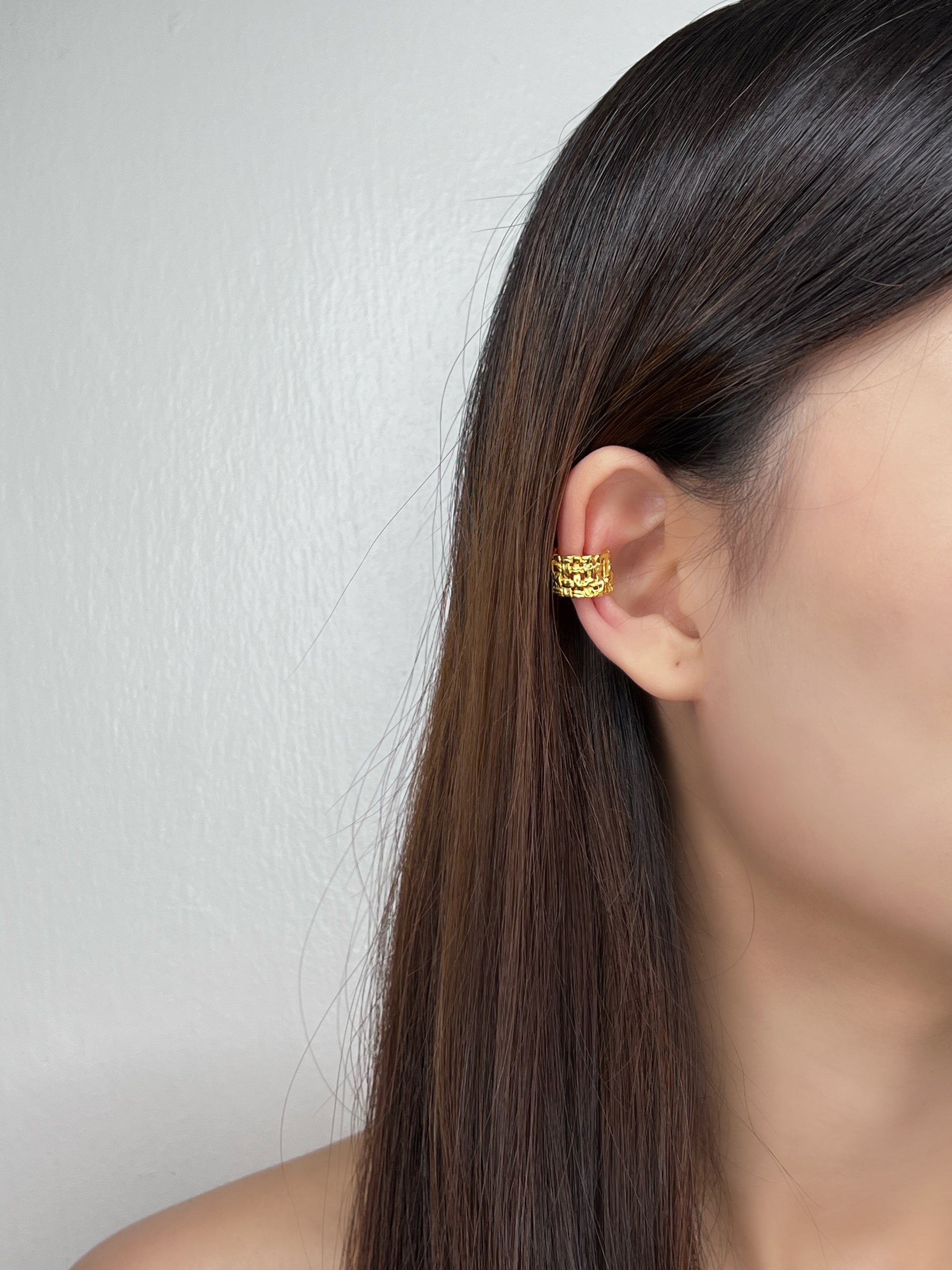 Editorial shot of a model showcasing the warm light reflection on the 18K gold vermeil surface.