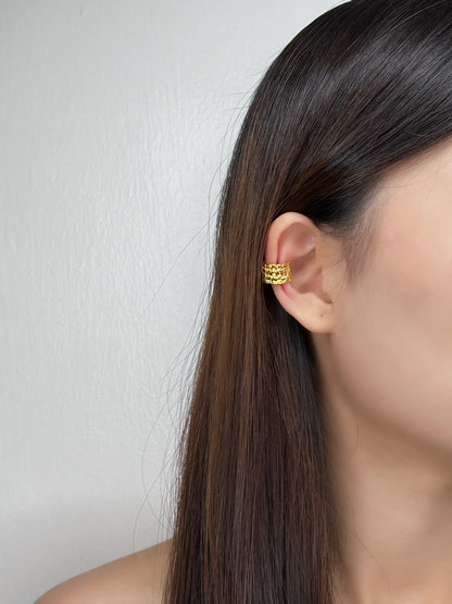 Editorial shot of a model showcasing the warm light reflection on the 18K gold vermeil surface.