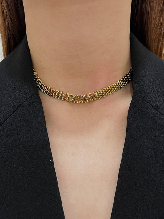 Close up lookbook profile of a model wearing a wide Danielle gold mesh chain necklace styled with a black blazer