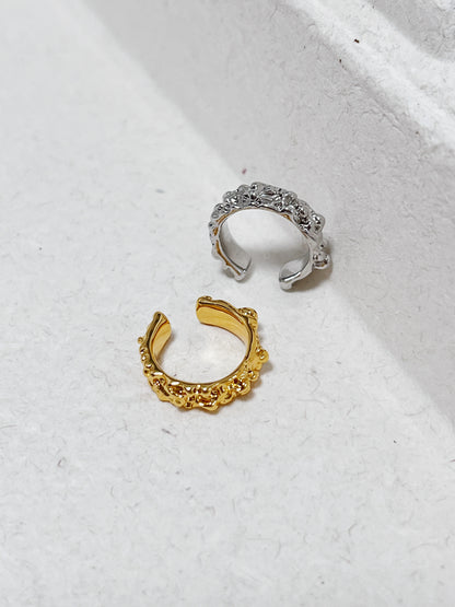 Top-down view of the textured Molten Ridge ear cuff on a clean minimalist background.